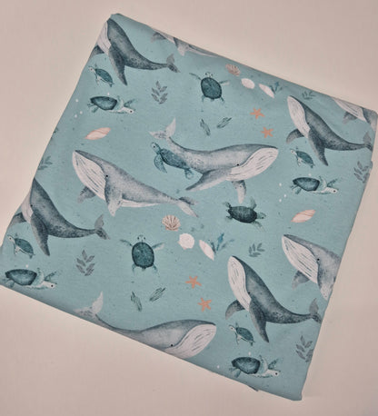 Fabric with whale and turtle pattern on a light blue background