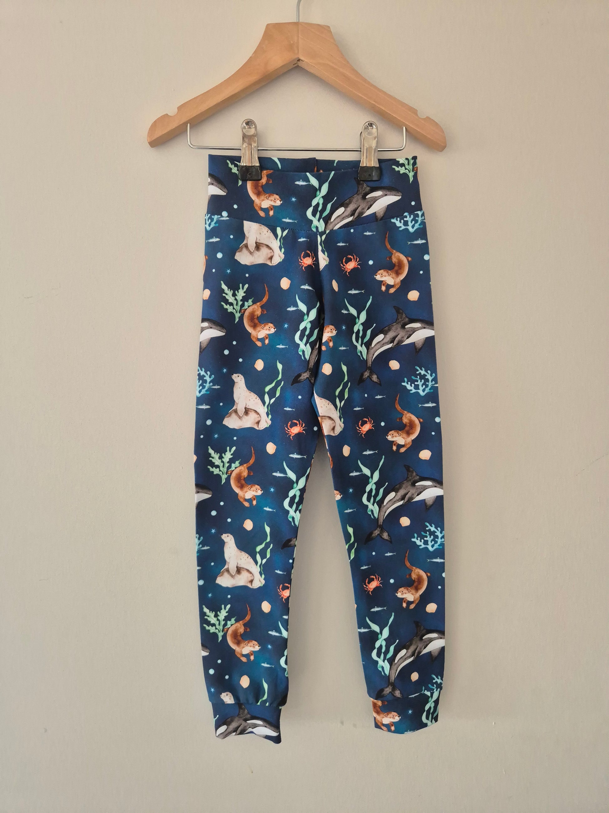 Children's leggings with sea creatures pattern on a hanger